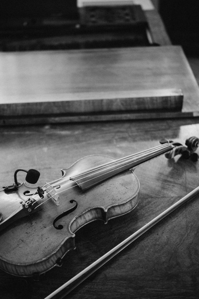 a-violin-and-bow-rest-on-a-wooden-surface-m5utwzca-yo